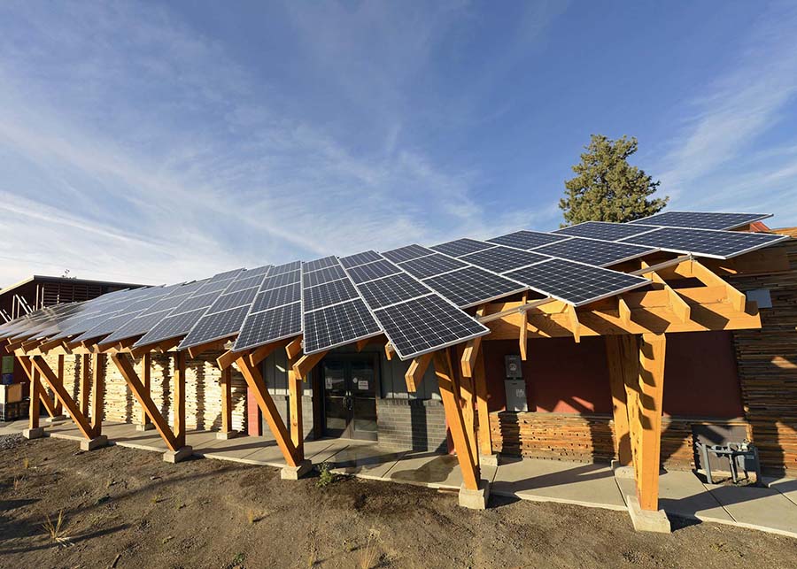 Large solar panels sit upon exposed cedar beams offering environmentally friendly energy and a shady overhang 